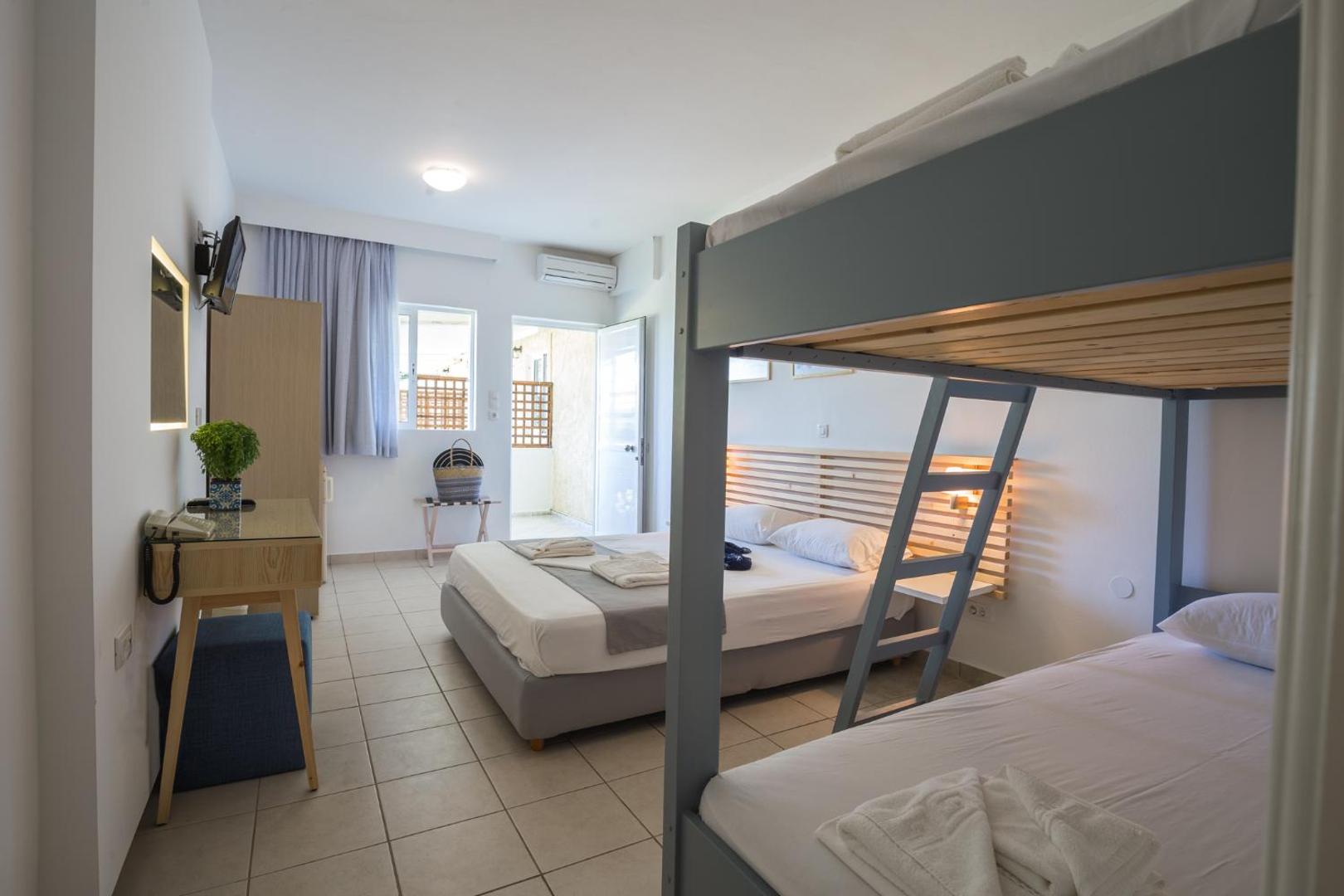 Niforeika Beach Hotel & Bungalows ģimenes numurs ar divstāvu gultu bērniem un divguļamo gultu vecākiem, gaišs interjers ar balkonu