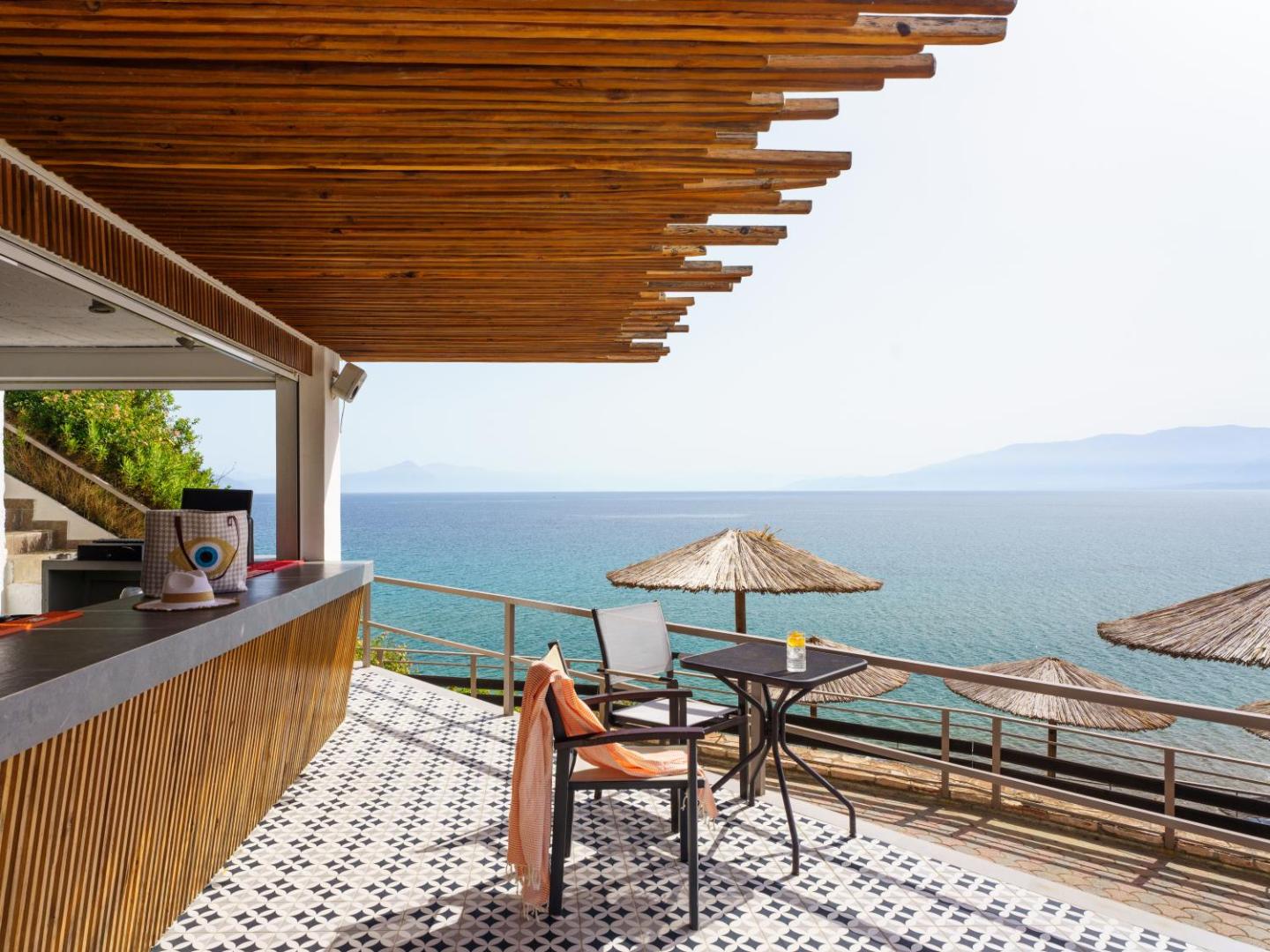 Niforeika Beach Hotel & Bungalows āra bāra terase ar skatu uz Jonijas jūru — koka apdare un stilīgas flīzes