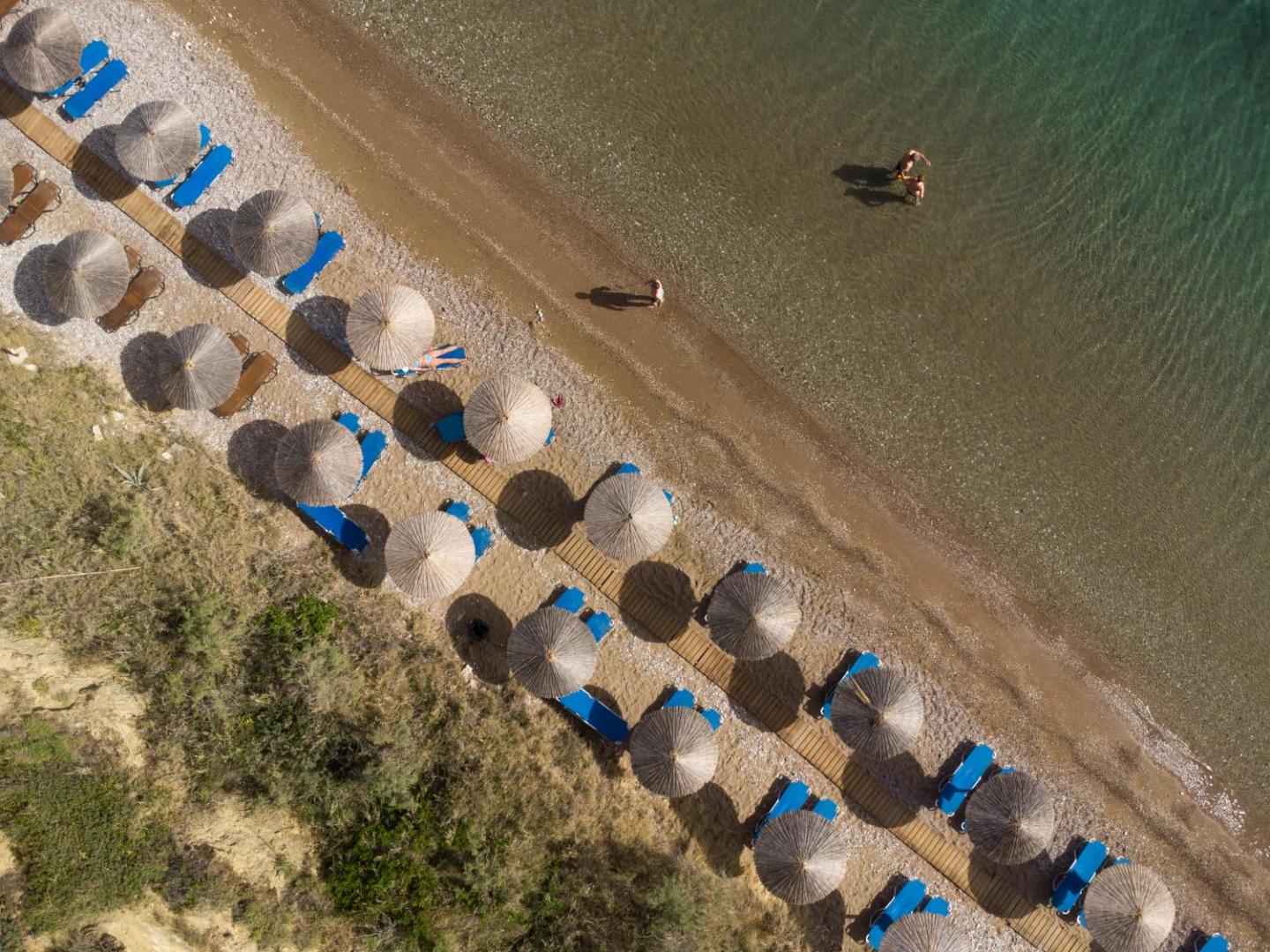 Niforeika Beach Hotel & Bungalows privātā pludmale no putna lidojuma — saulessargi un sauļošanās krēsli pie dzidra Jonijas jūras ūdens