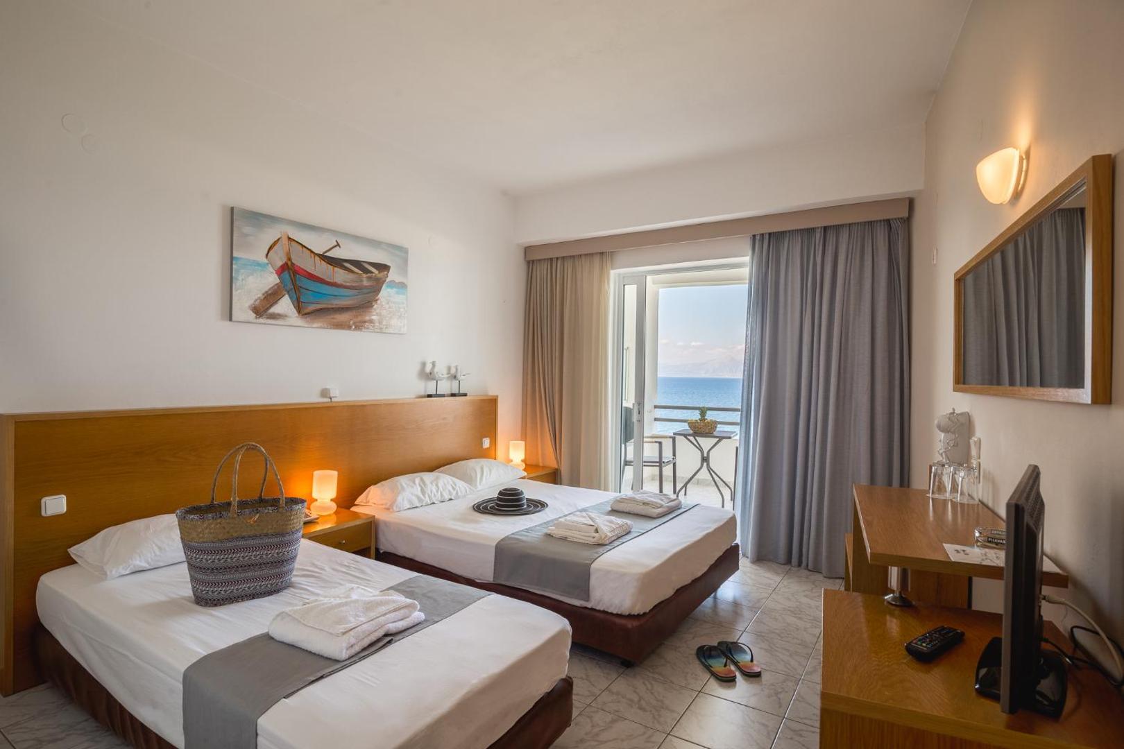 Niforeika Beach Hotel & Bungalows numurs ar divām gultām, koka mēbelēm un balkonu, no kura paveras plašs skats uz Jonijas jūru