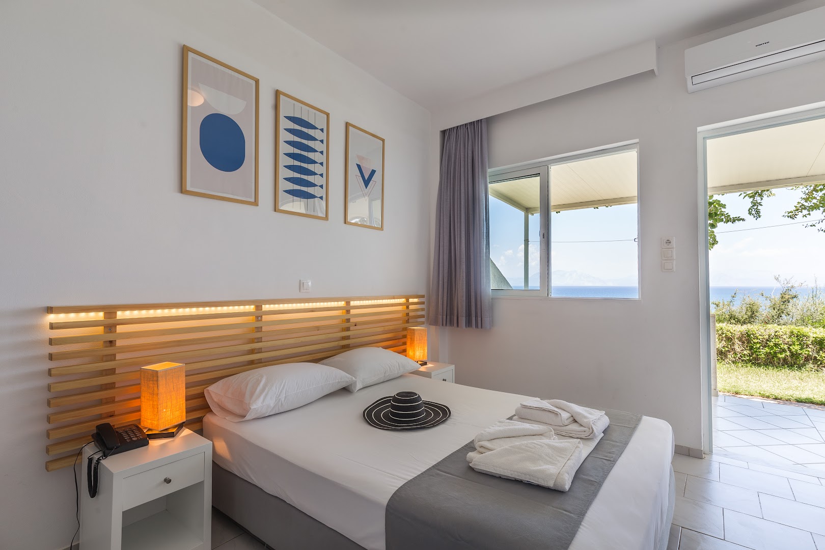 Niforeika Beach Hotel & Bungalows gaišs numurs ar divguļamo gultu, koka galvgali un skatu uz jūru caur logu Peloponēsas piekrastē