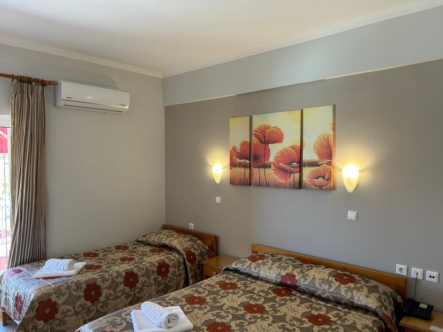 Brati II Beach Hotel gaišs numurs ar divām gultām, gleznu pie sienas un gaisa kondicionieri