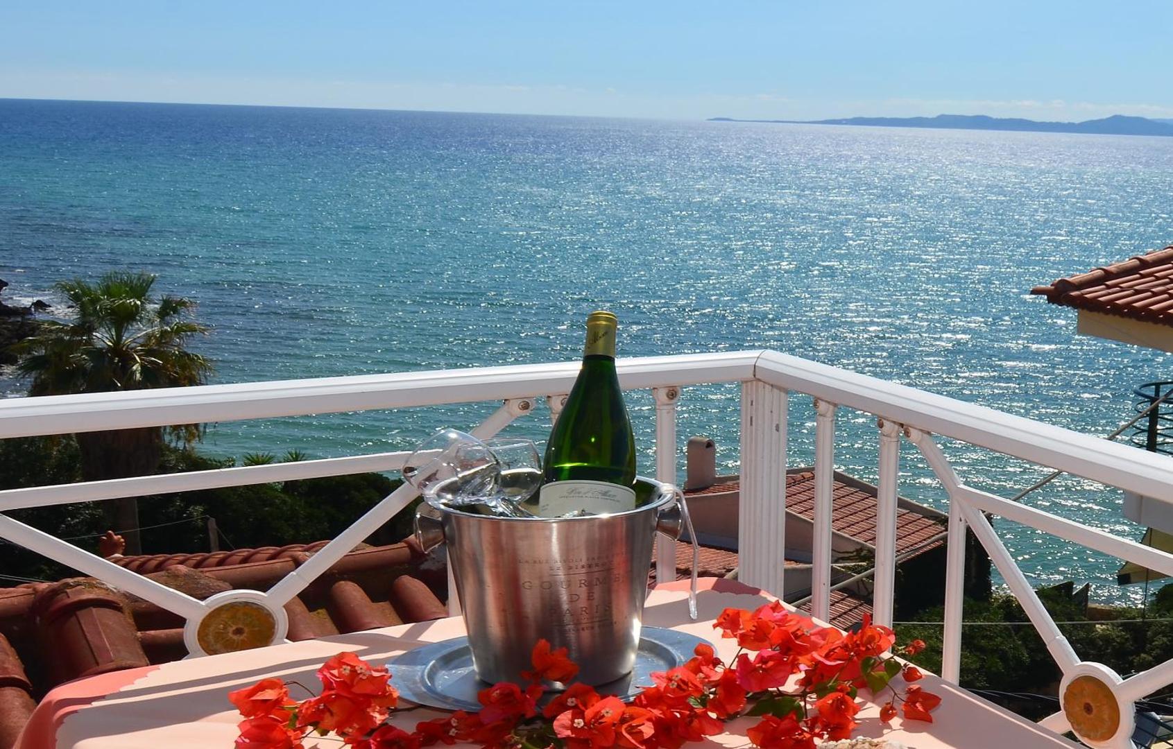 Brati II Beach Hotel balkona skats uz mirdzošu jūru — galds ar vīna dzesētāju un košiem ziediem