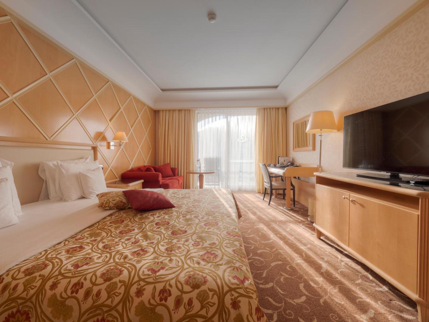 Splendid Conference & Spa Resort gaišs viesnīcas numurs ar lielu gultu, rakstāmgaldu un balkonu Bečiči kūrortā