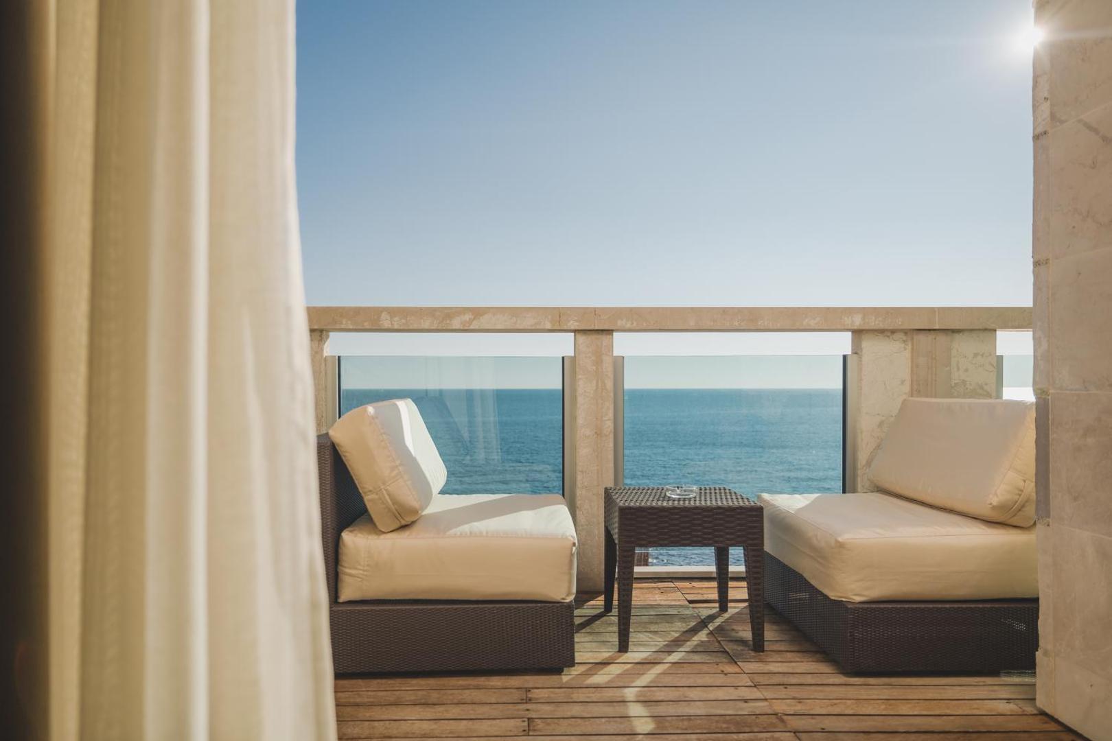 Avala Resort & Villas privātais balkons ar ērtiem zviļņiem un galdiņu tiešā Adrijas jūras krasta tuvumā