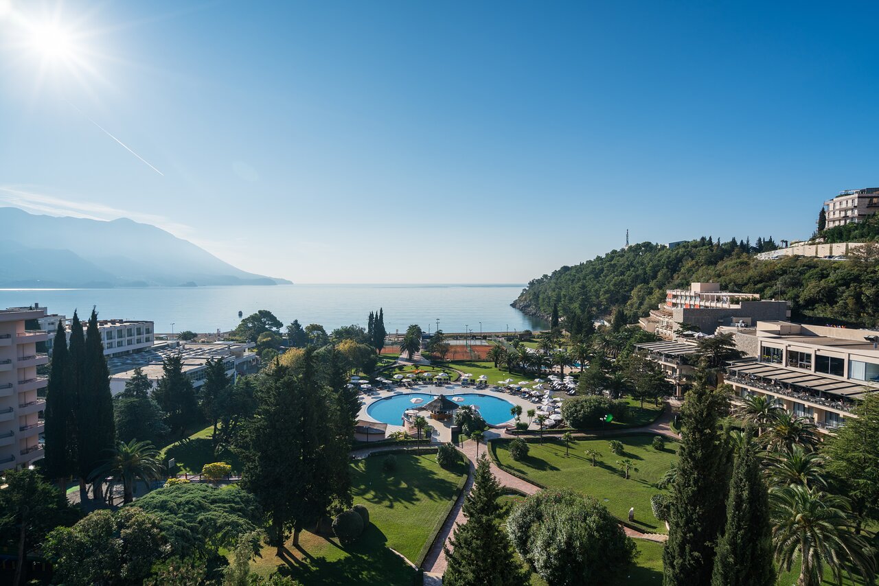 Iberostar Waves Bellevue panorāmas skats no augšas uz viesnīcas teritoriju, baseinu, dārzu un Adrijas jūras līci