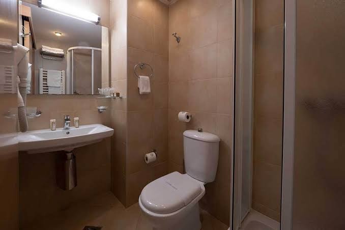 Montenegro Beach Resort numura vannas istaba ar dušas kabīni, izlietni, spoguli un gaišām flīzēm