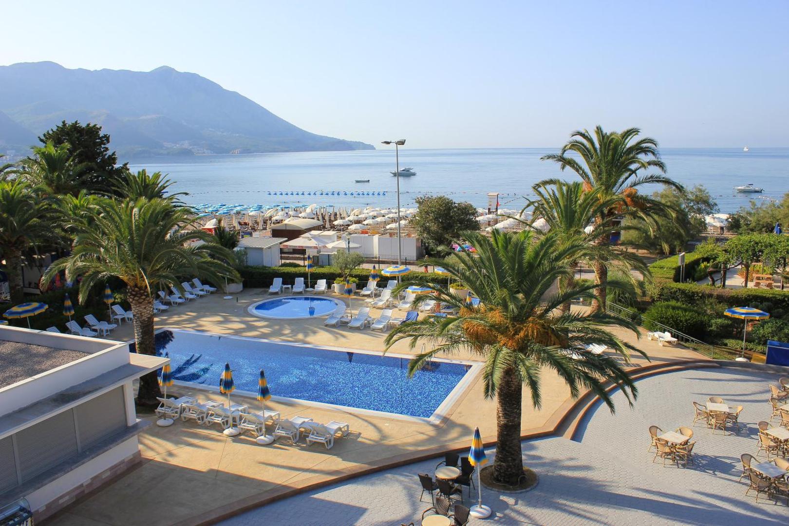Skats no augšas uz Montenegro Beach Resort baseinu kompleksu, bērnu baseinu un blakus esošo pludmali Bečiči