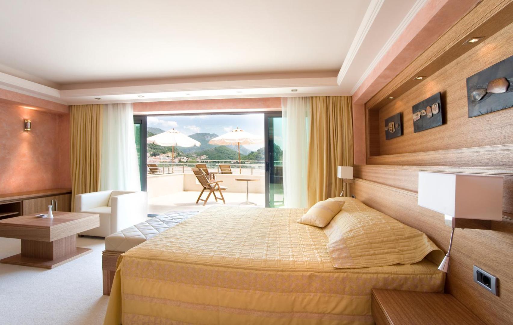 Monte Casa Spa & Wellness plašs viesnīcas numurs ar lielu gultu, atpūtas zonu un izeju uz saulainu terasi ar kalnu skatu