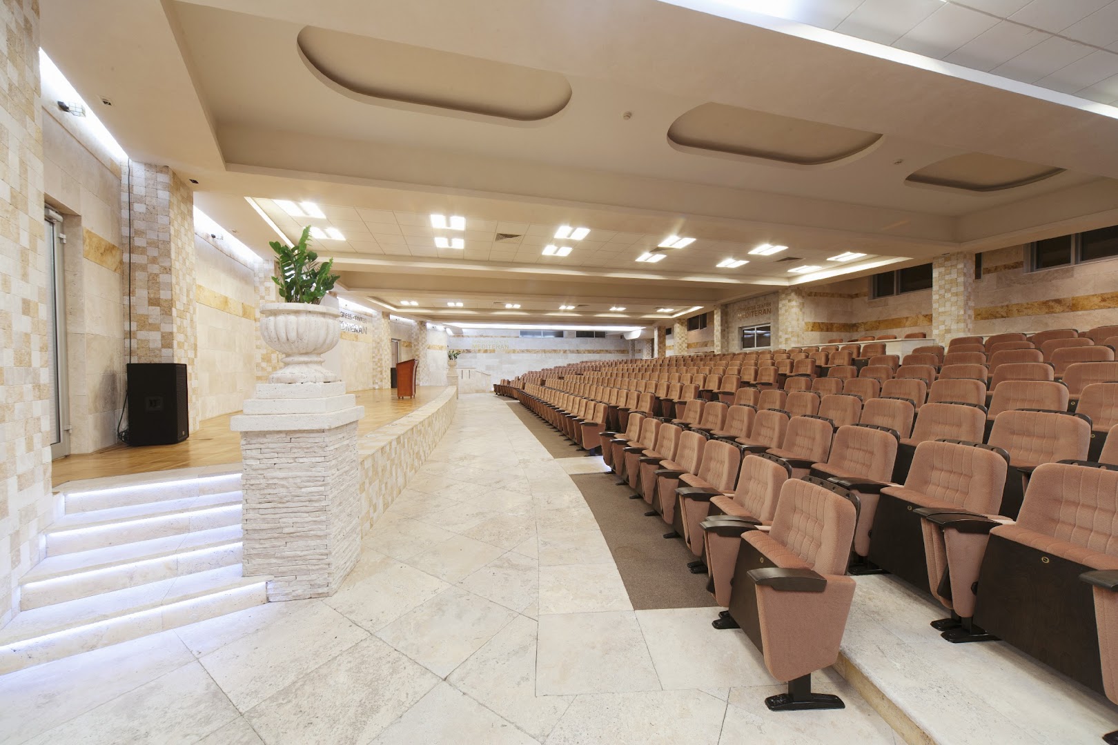 Viesnīcas Mediteran lielā konferenču zāle ar amfiteātra tipa sēdvietām un skatuvi pasākumiem Budvā, Melnkalnē.