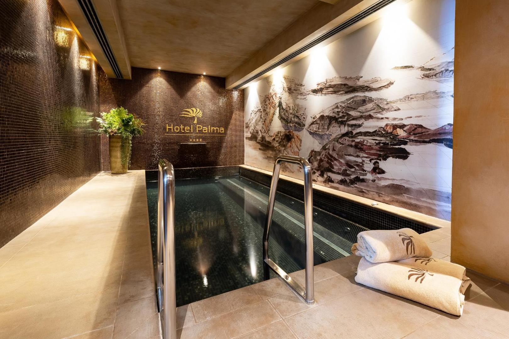 Hotel Palma spa centrs ar apsildāmu baseinu, māksliniecisku sienas gleznojumu un mīkstiem dvieļiem atpūtas zonā