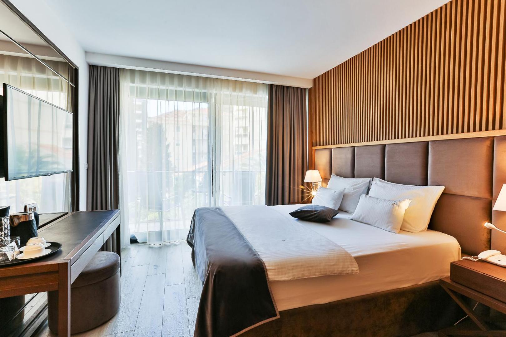 Hotel Fagus by Aycon viesnīcas numurs ar koka apdari, TV zonu un izeju uz balkonu Budvas kūrortā