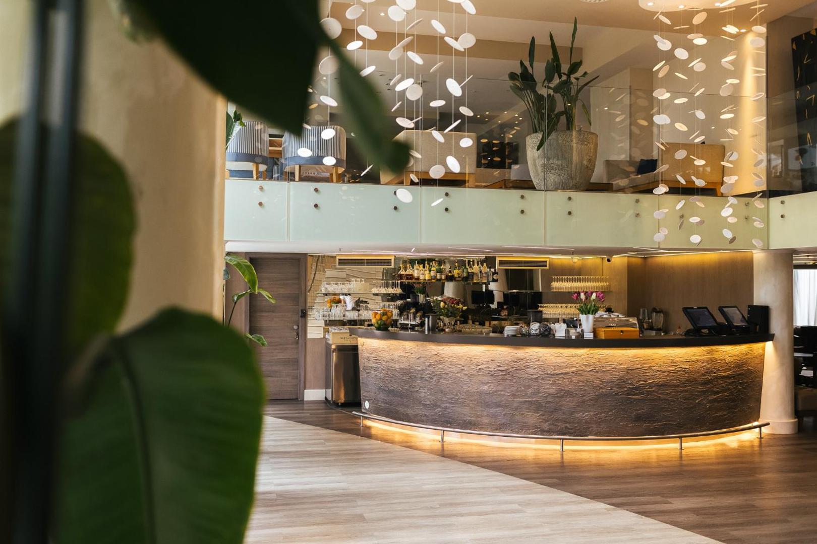 Palmon Bay Hotel & SPA modernais lobby bārs ar akmens apdari un dizaina elementiem, skats uz otro stāvu un augu dekorācijām