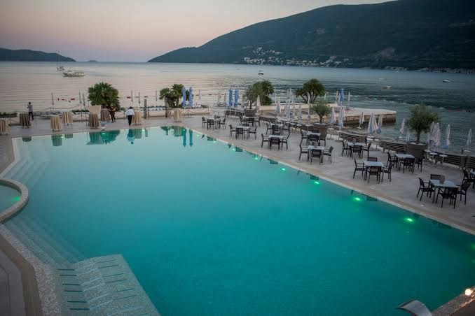 Palmon Bay Hotel & SPA āra baseins piekrastē ar skatu uz Adrijas jūru un kalniem saulrieta laikā
