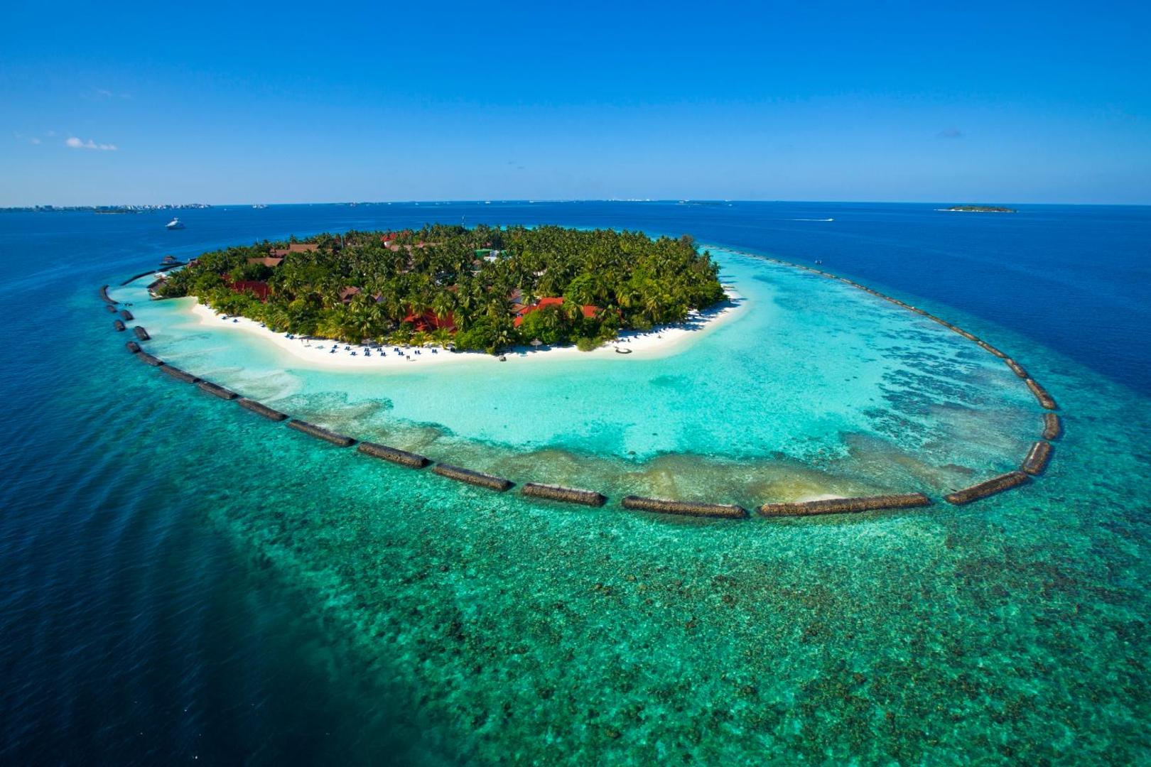 Kurumba Maldives kūrorta panorāmas skats uz visu salu, ko ieskauj kristāldzidrs ūdens un balto smilšu pludmales Maldīvās.