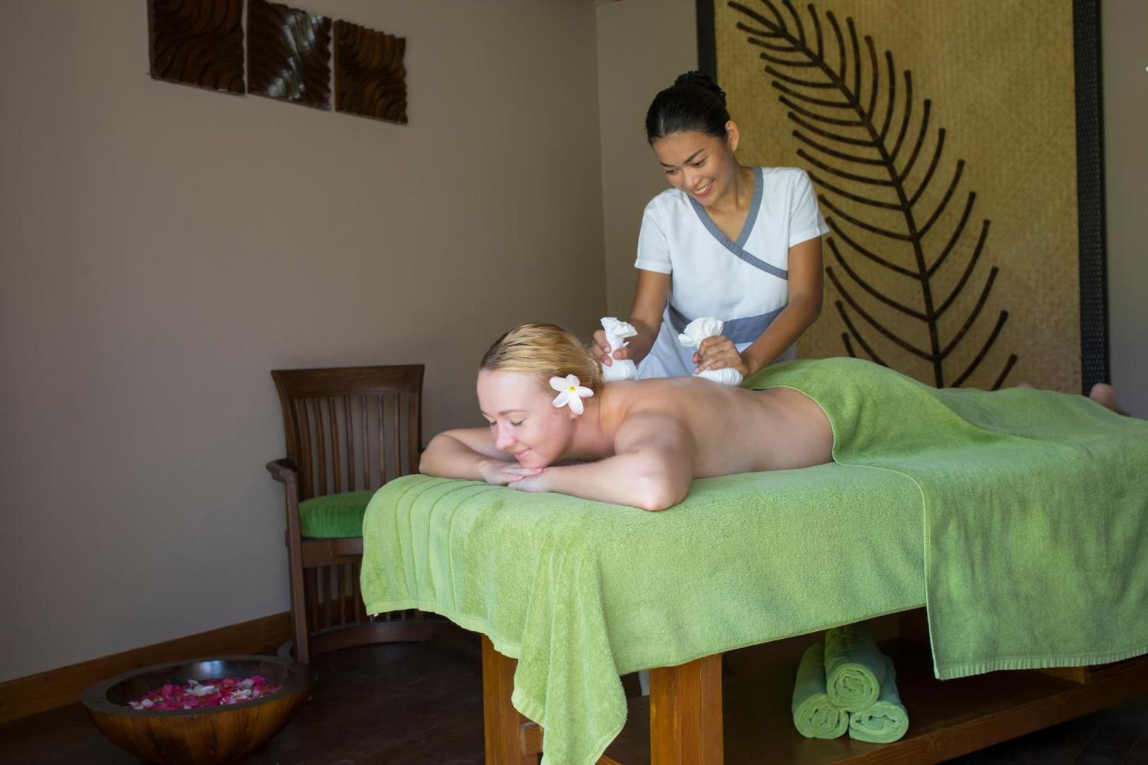Kurumba Maldives spa procedūra — speciāliste veic masāžu ar zāļu maisiņiem viesnīcas relaksācijas centrā