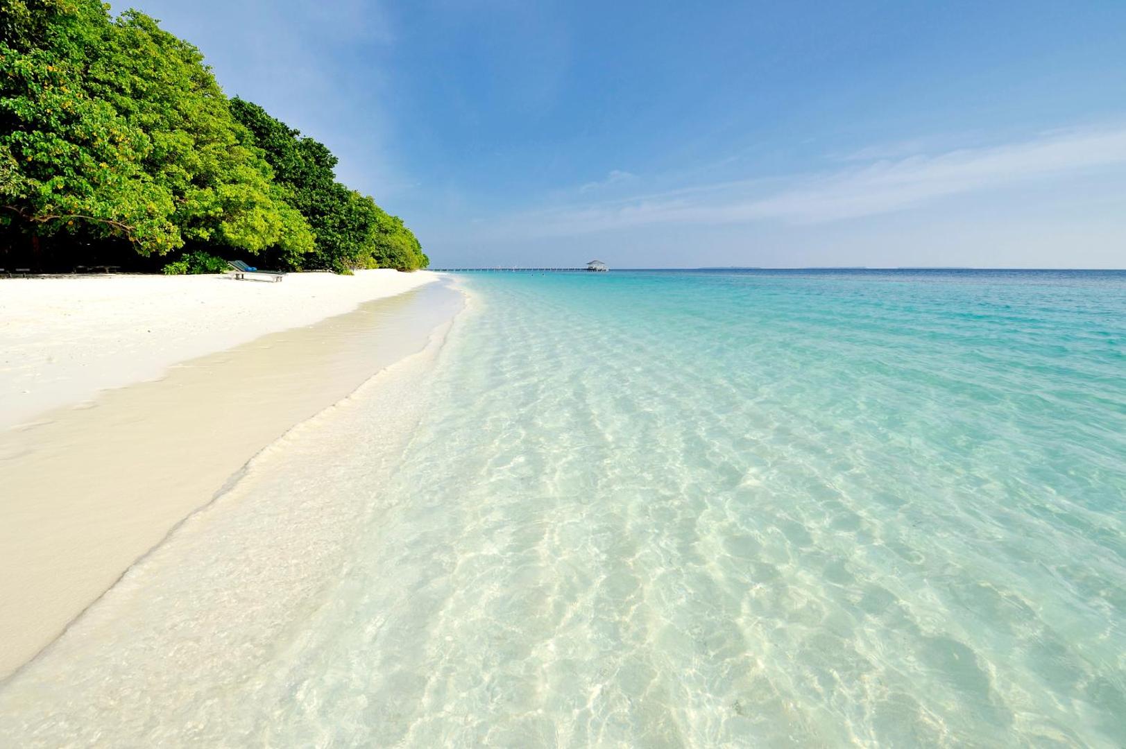 Royal Island Resort & Spa balto smilšu pludmale ar kristāldzidru ūdeni un zaļojošu tropu mežu salas malā
