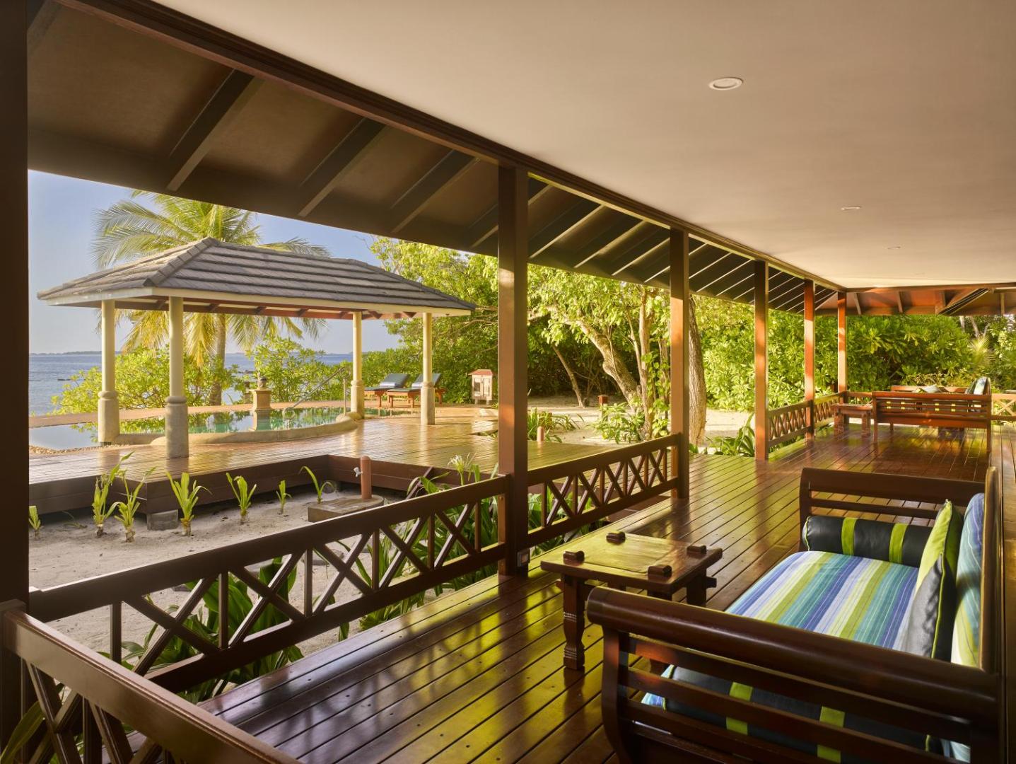 Royal Island Resort & Spa plaša koka veranda ar ērtiem dīvāniem un skatu uz tropisko dārzu un okeāna piekrasti