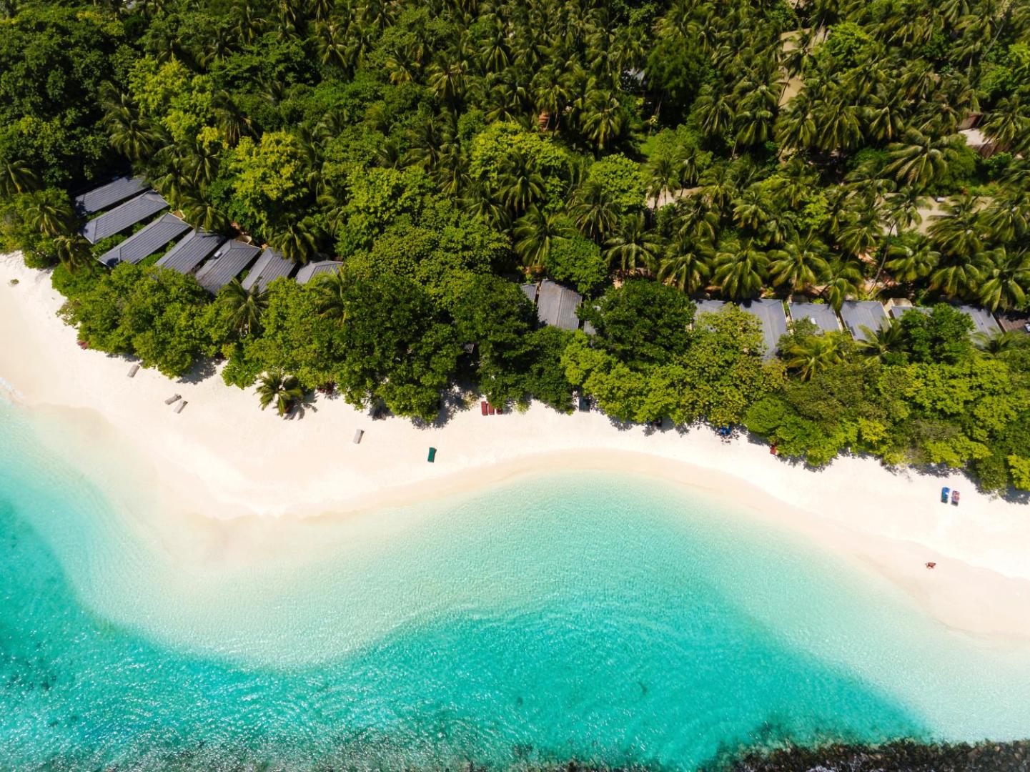 Royal Island Resort & Spa bungalo komplekss tropu dārzā pie pašas okeāna piekrastes ar tirkīza krāsas ūdeni