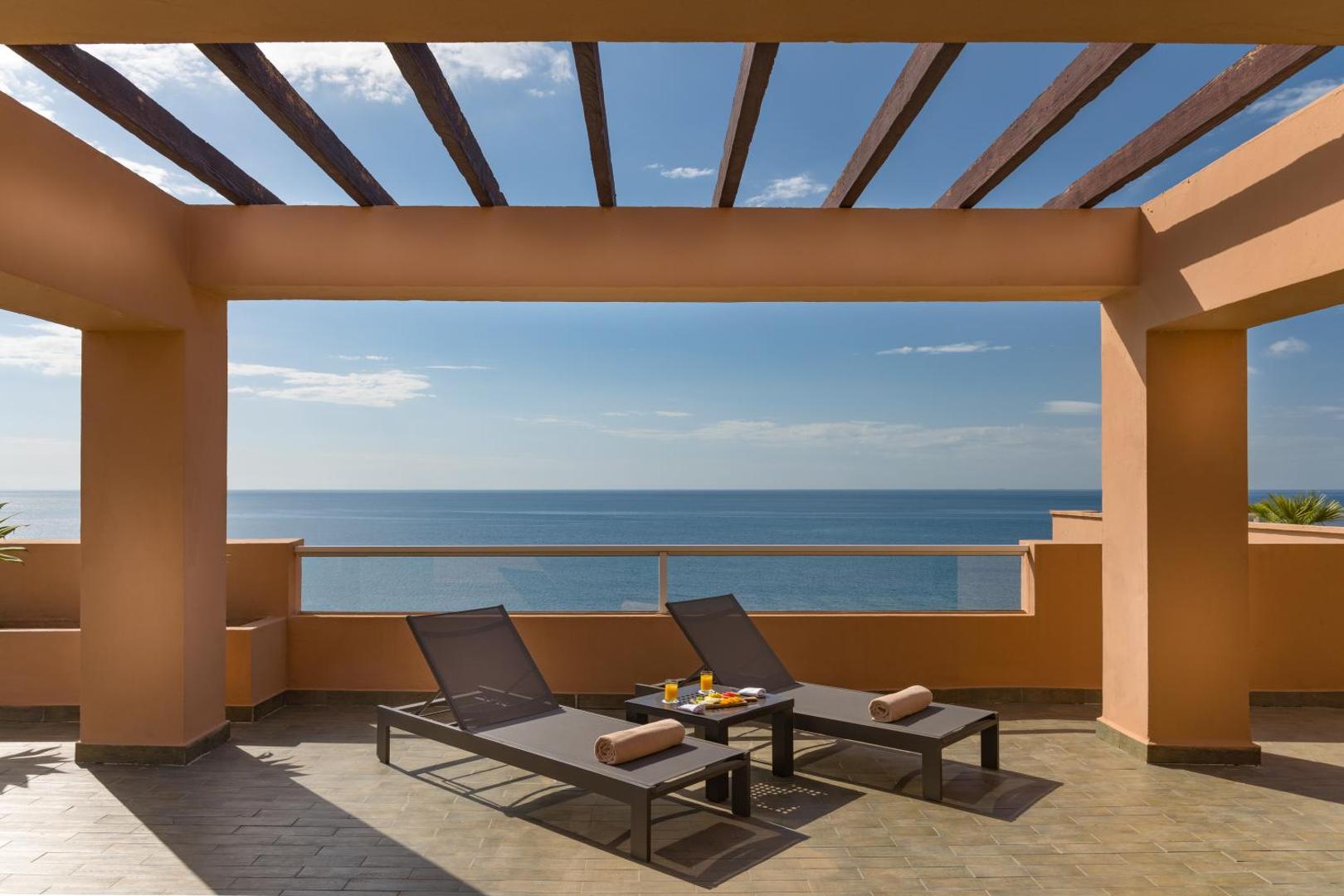 Elba Estepona Gran Hotel And Thalasso Spa numura terase ar sauļošanās krēsliem un panorāmas skatu uz Vidusjūru Esteponā, Spānijā