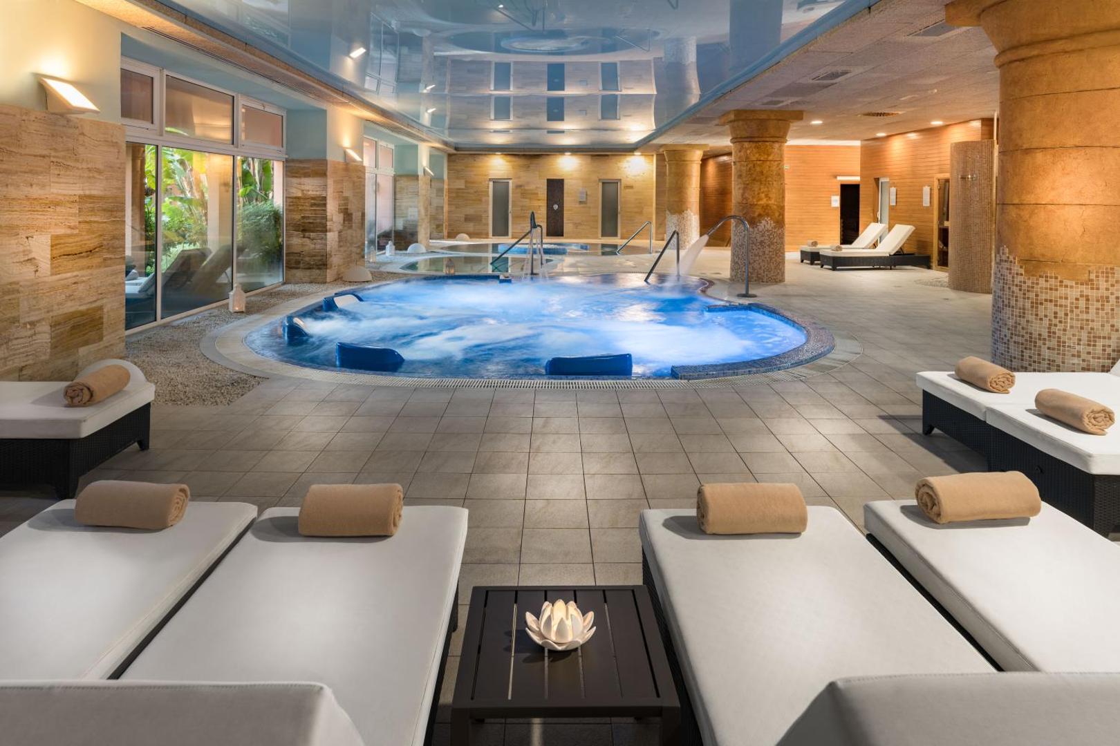 Elba Estepona Gran Hotel Thalasso Spa iekštelpu baseins ar hidromasāžas zonu un ērtiem atpūtas krēsliem relaksācijai