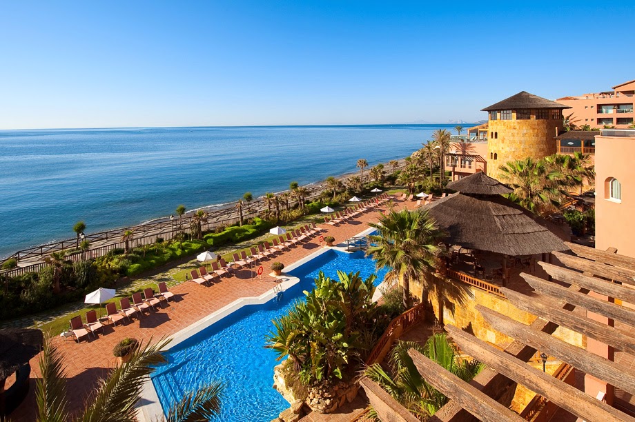 Elba Estepona Gran Hotel And Thalasso Spa skats no augšas uz āra baseinu, sauļošanās krēsliem un Vidusjūras piekrasti Esteponā