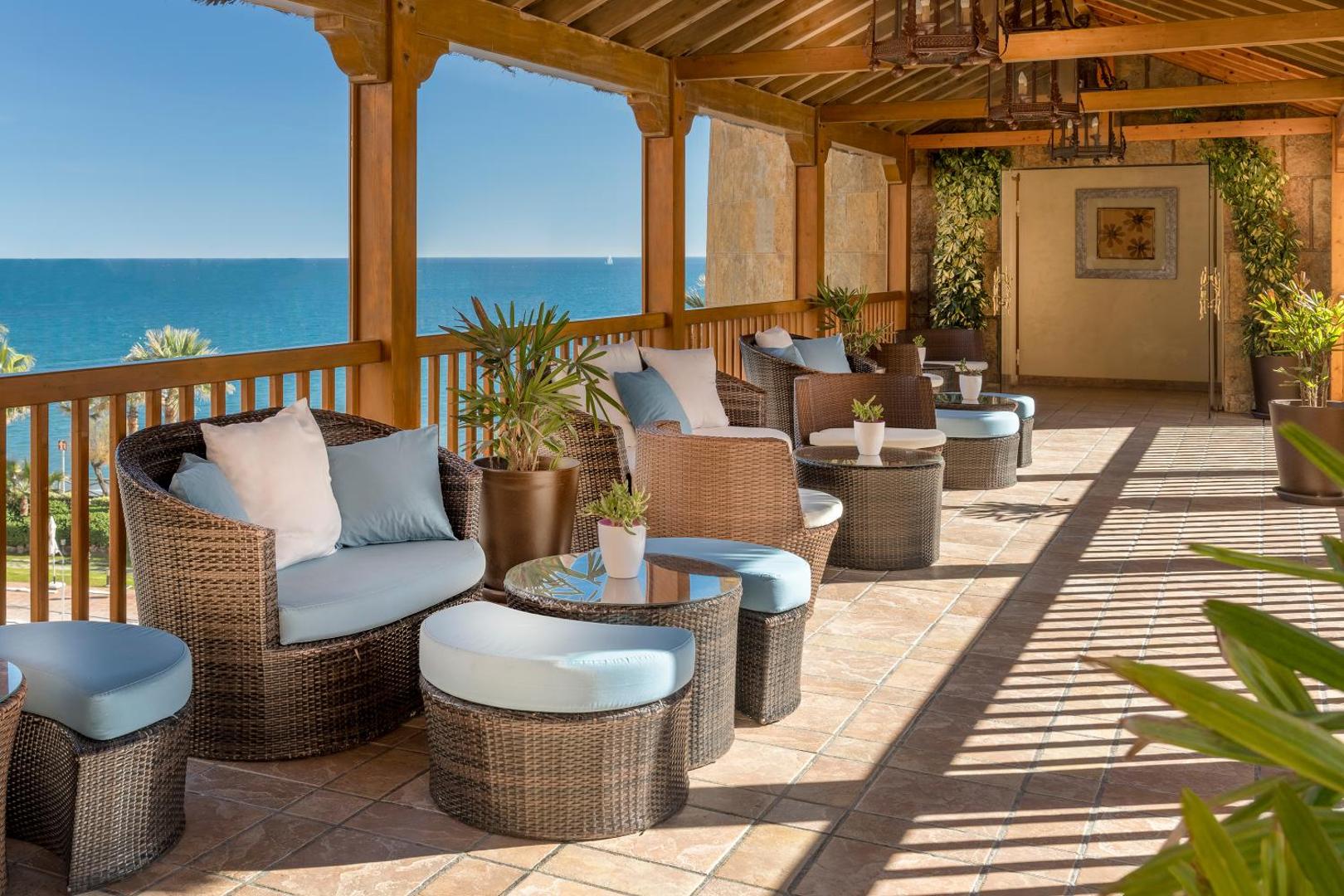 Elba Estepona Gran Hotel And Thalasso Spa terase ar pītiem atpūtas krēsliem un skatu uz Vidusjūru Esteponā, Spānijā.