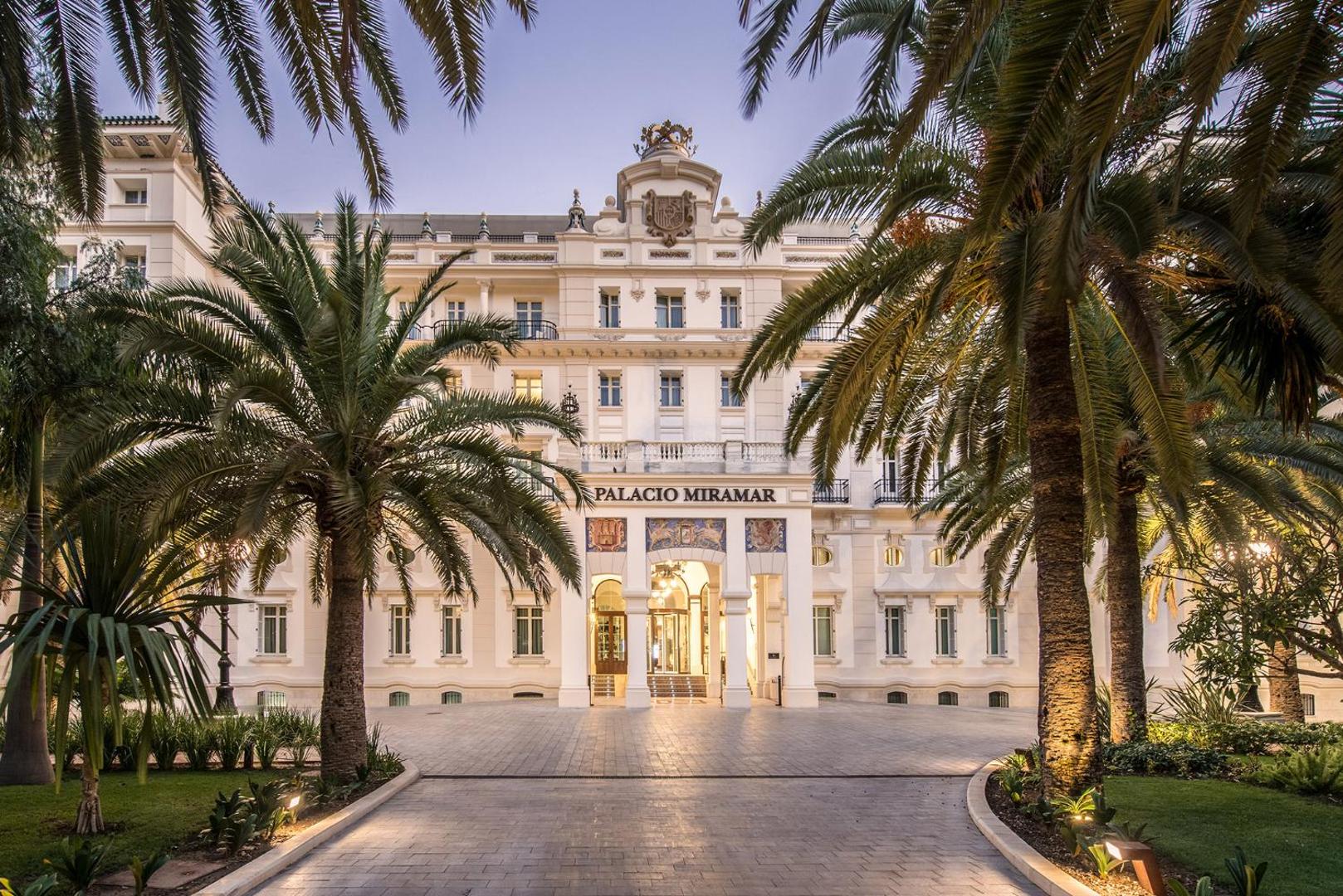 Skats uz Gran Hotel Miramar ieeju dienas gaismā Malagā — vēsturiska arhitektūra, palmas un sakopta teritorija piekrastē