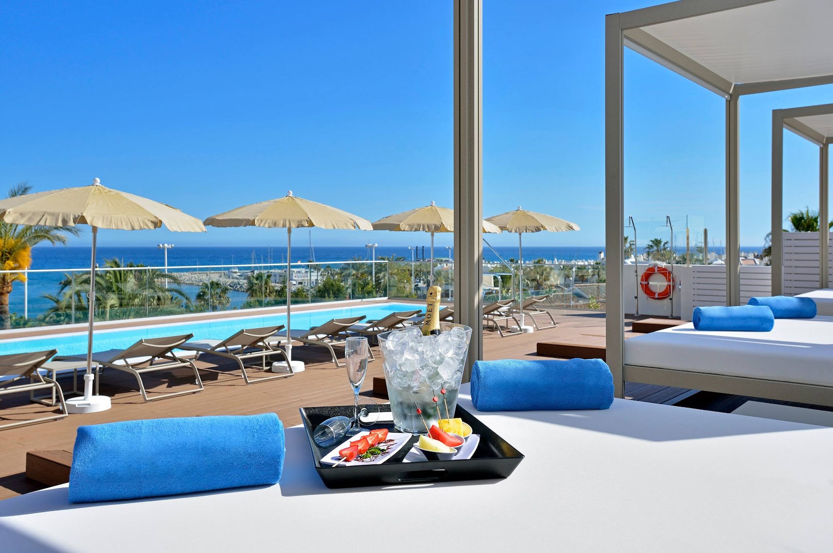 Sol House Costa del Sol jumta terase ar atpūtas gultām, šampanieti un augļiem — skats uz Vidusjūru un baseinu
