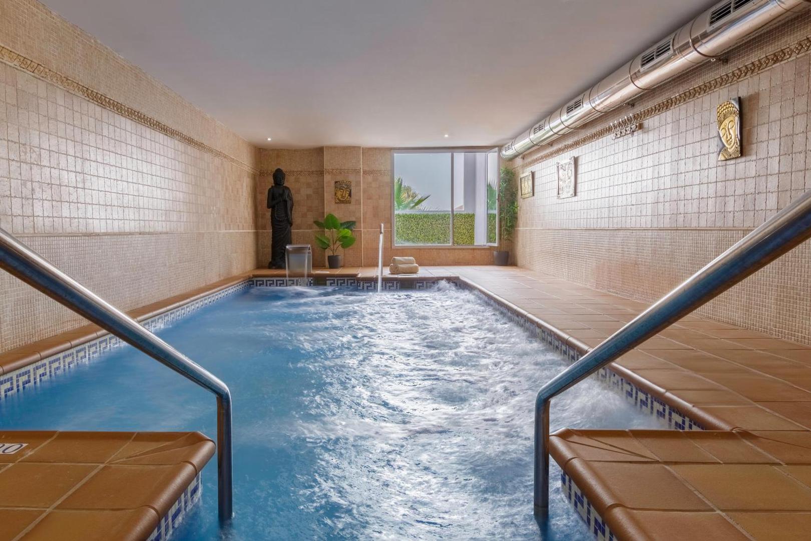 Best Benalmadena spa centrs ar iekštelpu baseinu, kura malās izvietotas Budas statujas un dekoratīvas flīzes relaksējošā gaisotnē