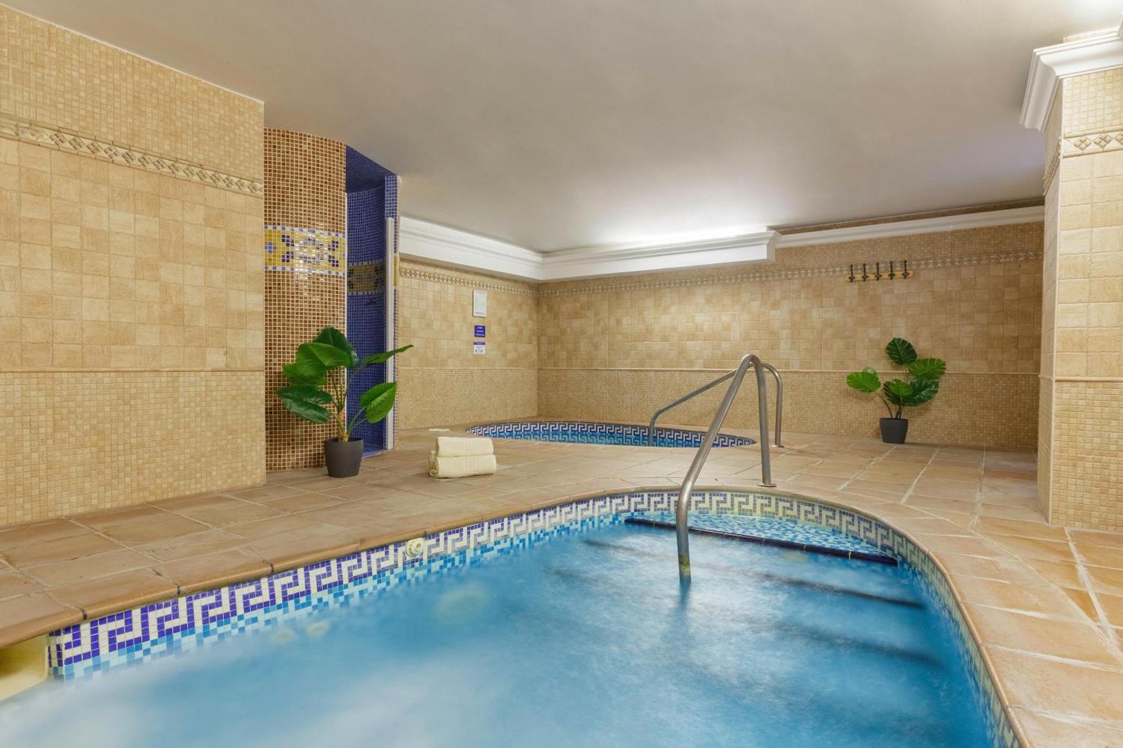 Viesnīcas Best Benalmadena spa zonas džakuzi un hidromasāžas baseini ar gaišām flīzēm un dekoratīviem telpaugiem