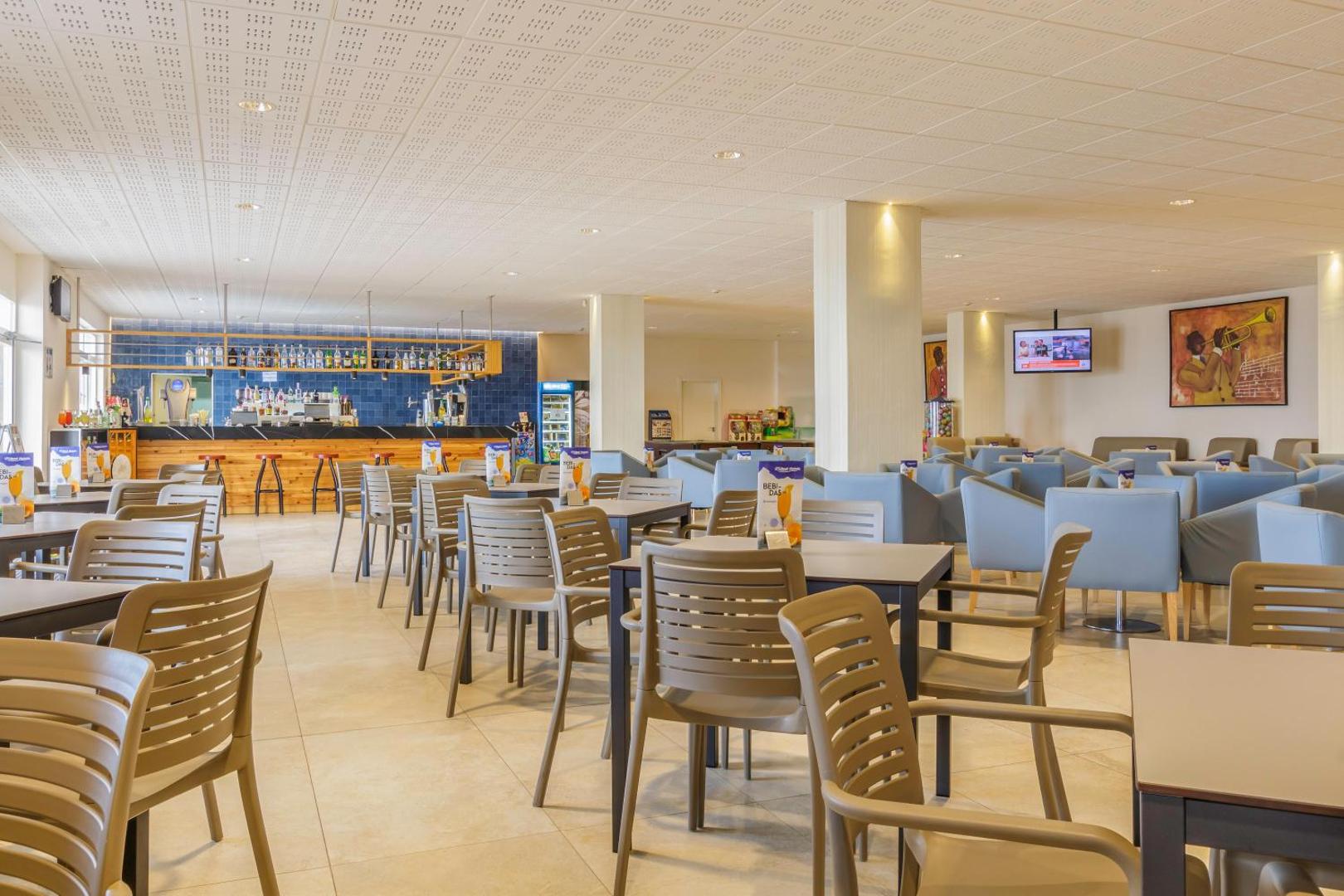 Viesnīcas Best Benalmadena plašā kafejnīcas un atpūtas zona ar daudziem galdiņiem, krēsliem un bāru fonā