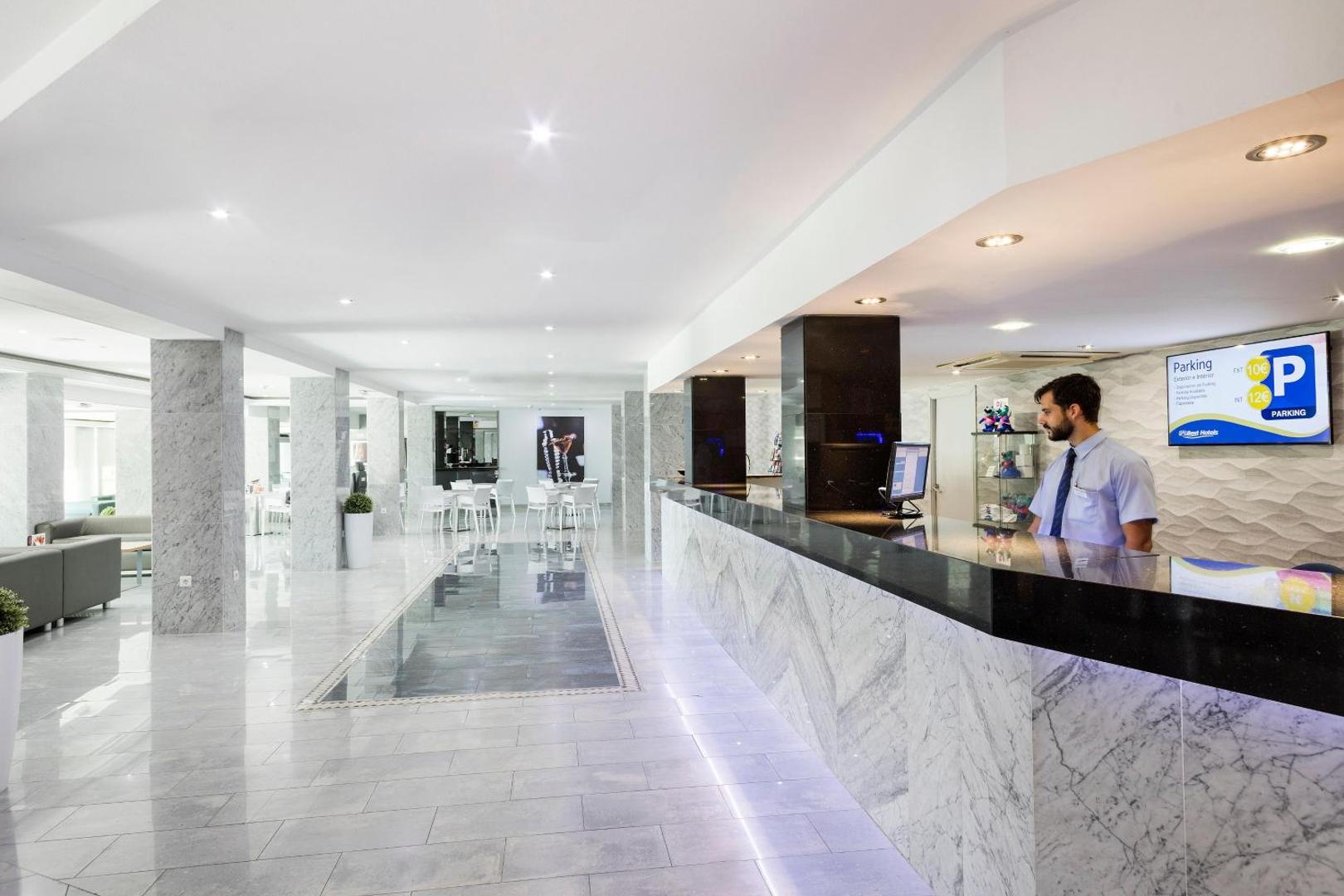 Best Siroco viesnīcas recepcijas zona ar marmora apdari un modernu leti — gaišs lobby vestibils ar atpūtas dīvāniem