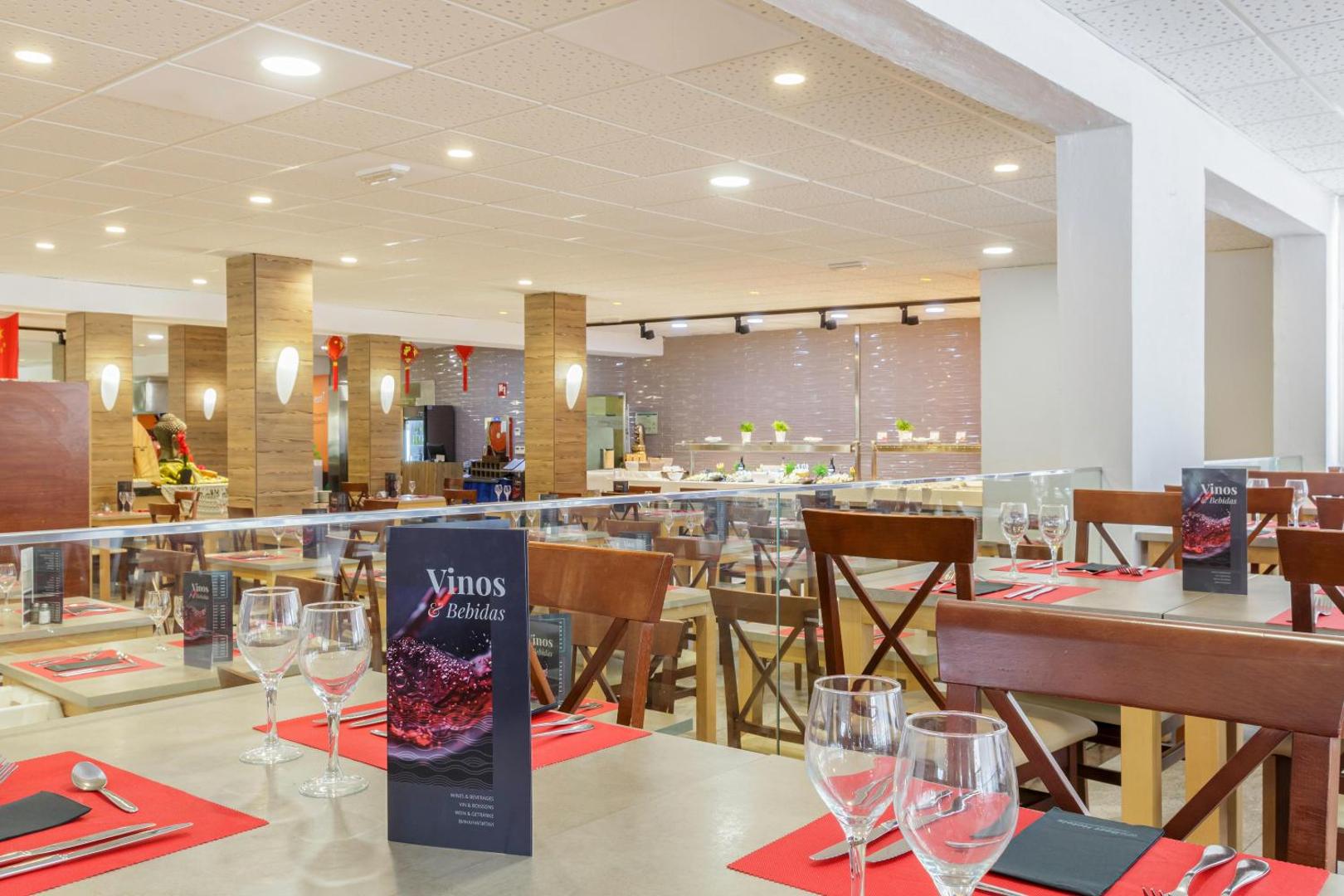 Best Siroco viesnīcas restorāna zāle ar klātiem galdiem, vīna kartēm un bufetes zonu fonā — gaišs un mūsdienīgs interjers