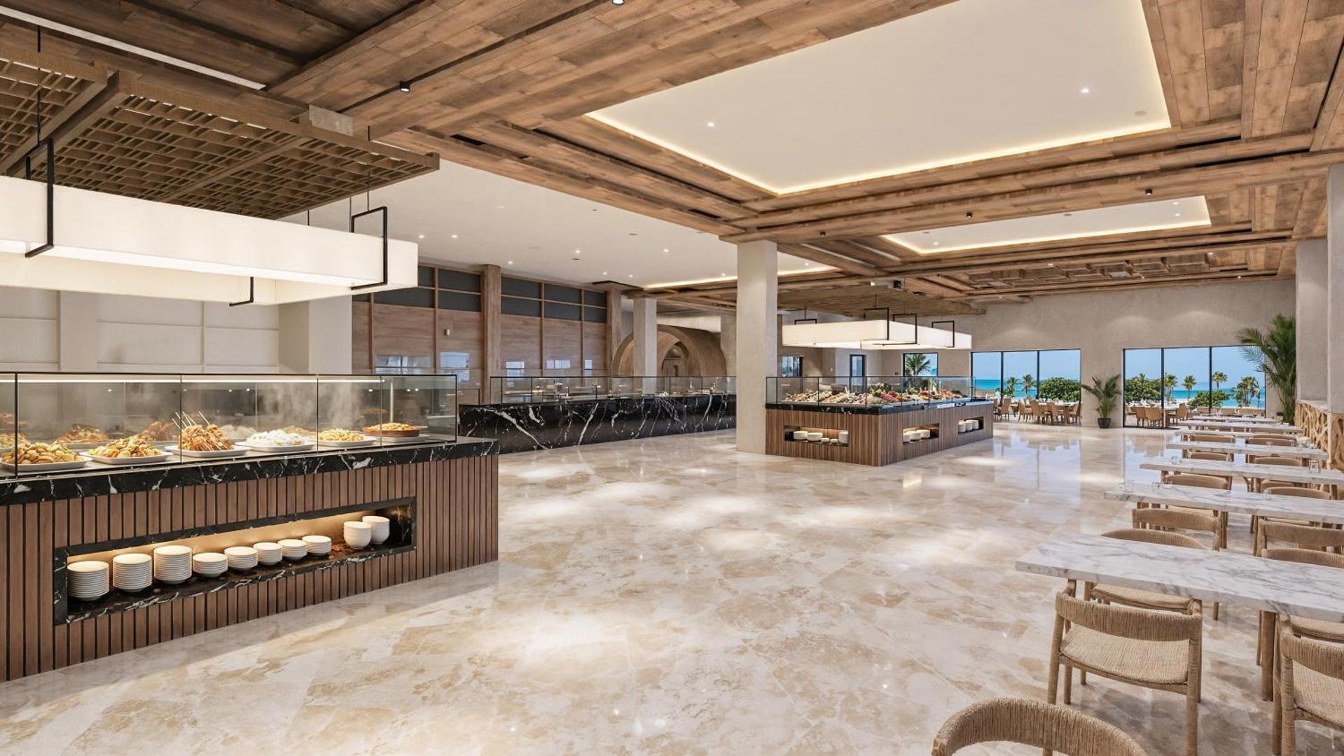 Nana Royal Premium Resort galvenais restorāns ar plašu bufetes zonu, marmora grīdām un koka griestu apdari Hersonisā, Krētā.