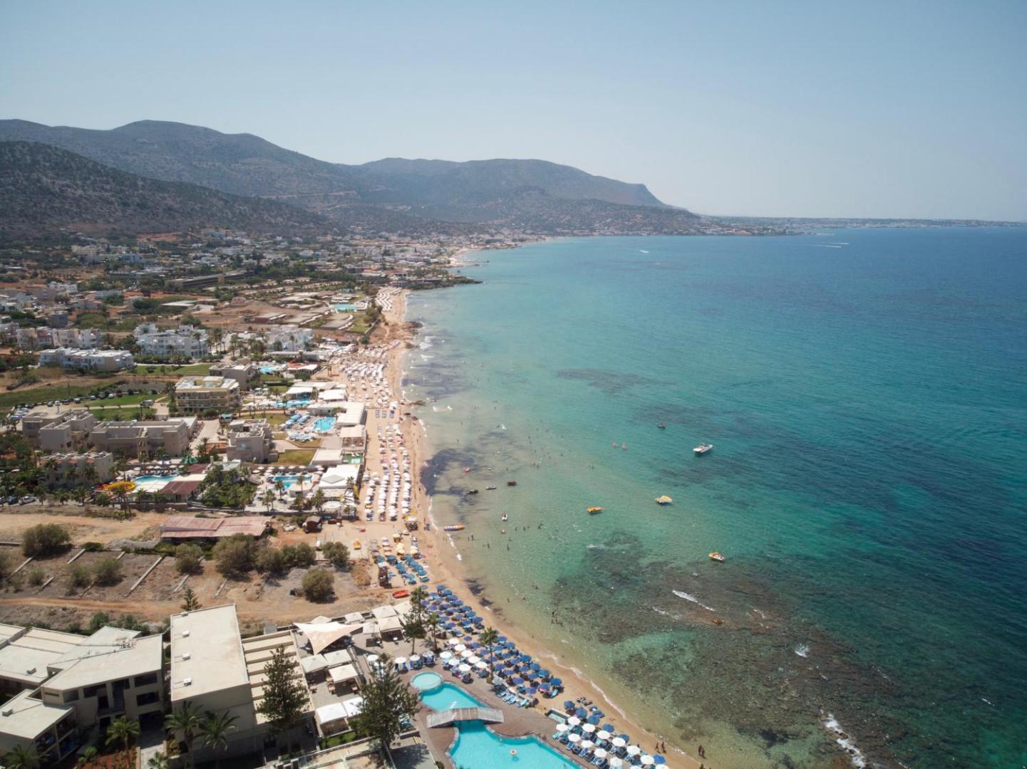 Enorme Ammos Beach Resort skats no putna lidojuma uz Malijas piekrasti Krētā — viesnīcas komplekss, baseini un plaša smilšu pludmale