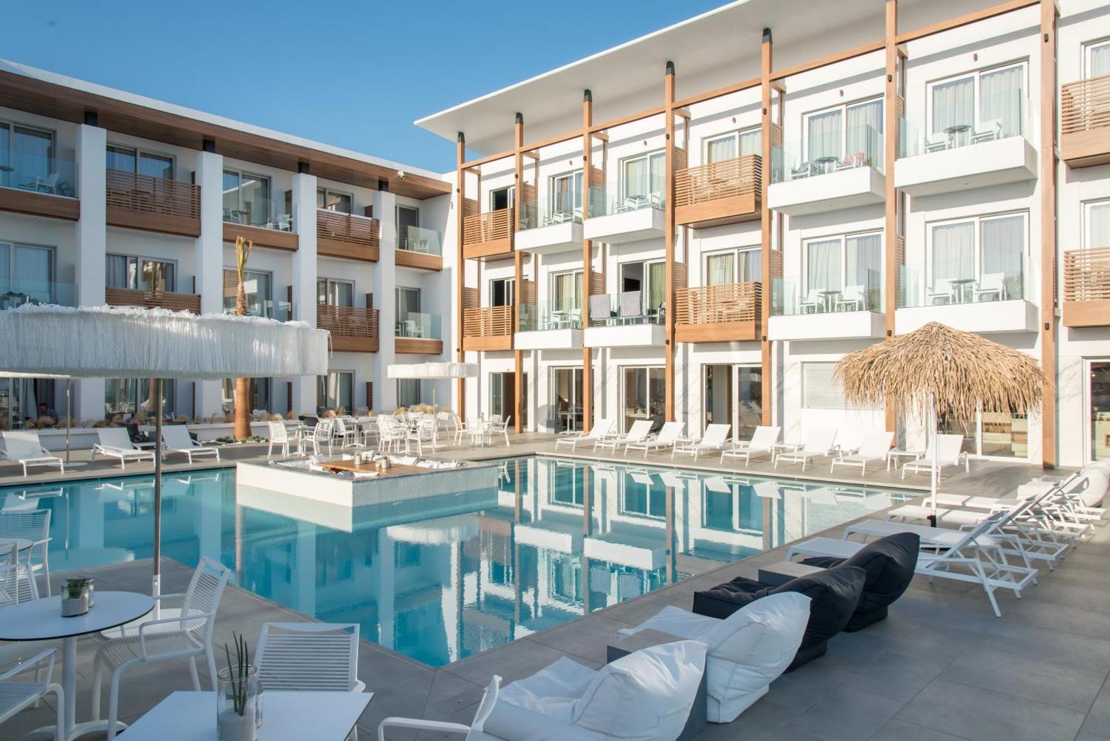 Enorme Ammos Beach Resort iekšpagalms ar baseinu, sauļošanās krēsliem un moderniem numuriem ar balkoniem