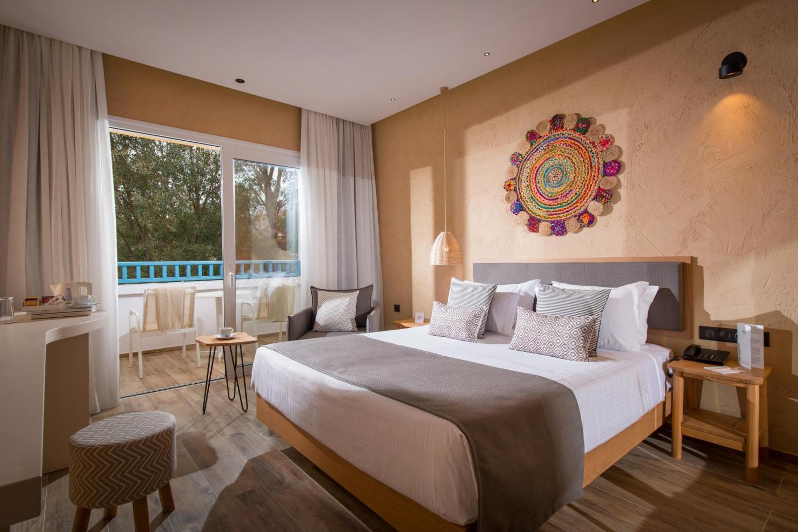 Fodele Beach & Water Park Resort numurs siltos smilšu toņos ar etniska stila sienas dekoru un mēbelētu balkonu