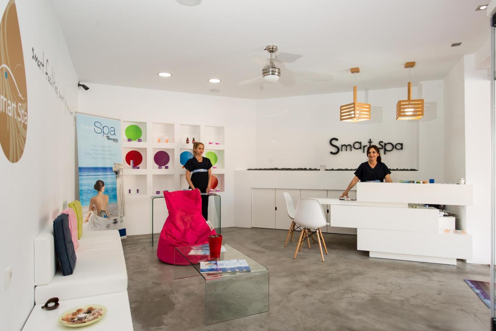 Fodele Beach & Water Park Resort Smart Spa centra recepcija ar modernu dizainu, baltām mēbelēm un personālu