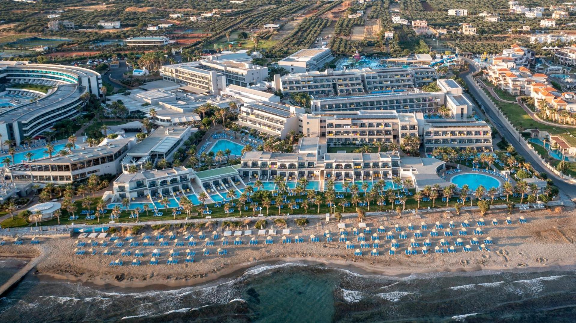 Lyttos Beach kūrorta skats no putna lidojuma Krētā — plaša teritorija pie pašas jūras ar vairākiem baseiniem un smilšu pludmali