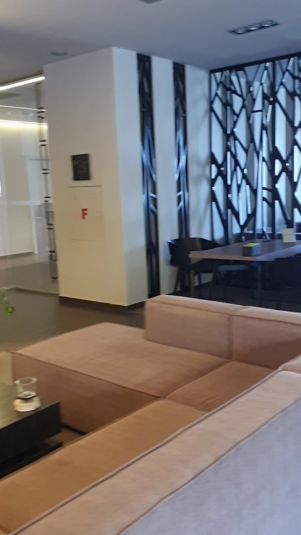 NEMA Design Hotel & Spa vestibila atpūtas zona ar modernu dīvānu, dekoratīvām sienas paneļu detaļām un galdiņu Hersonisā, Krētā