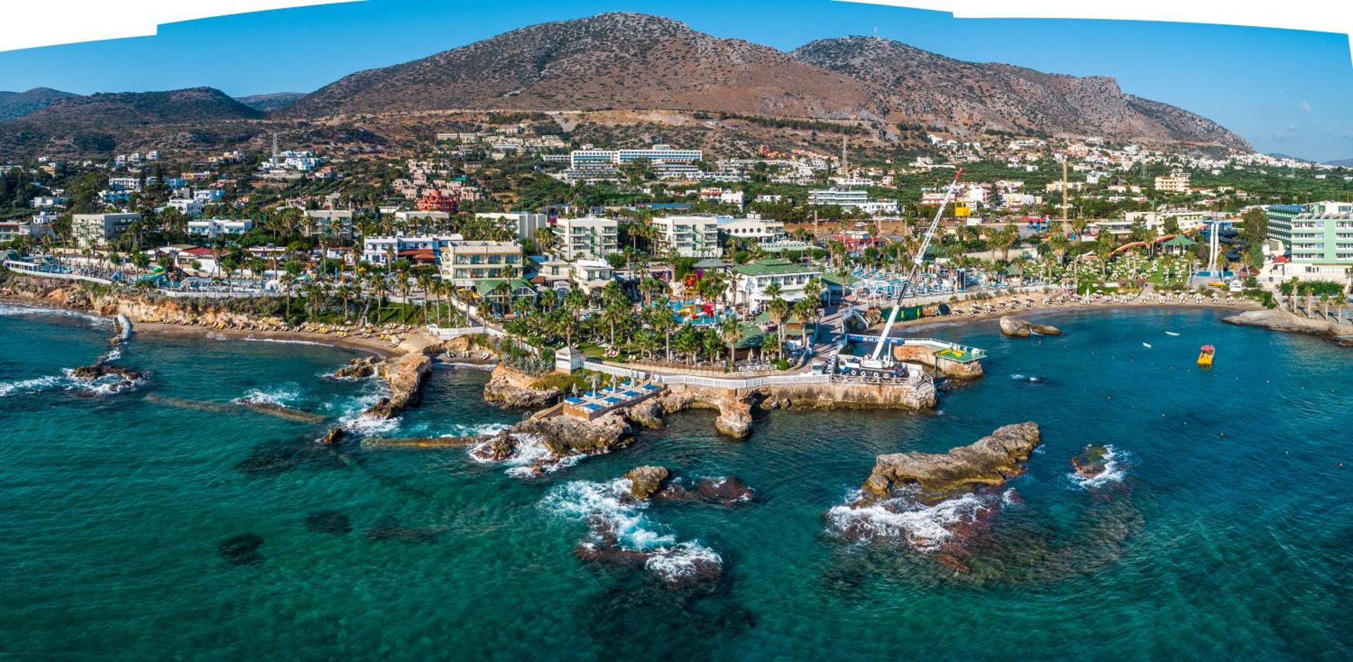 Star Beach Village & Water Park panorāmas skats Hersonisā, Krētā — viesnīcas komplekss pie Egejas jūras ar kalnu fonu un akvaparku