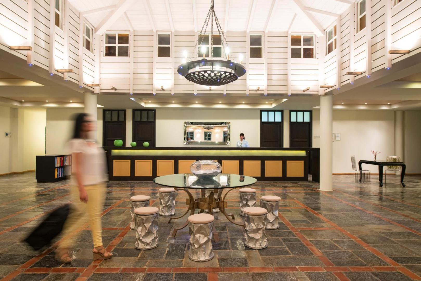Silva Beach viesnīcas lobby zona ar modernu recepcijas galdu, dizaina krēsliem un augstiem griestiem gaišos toņos.