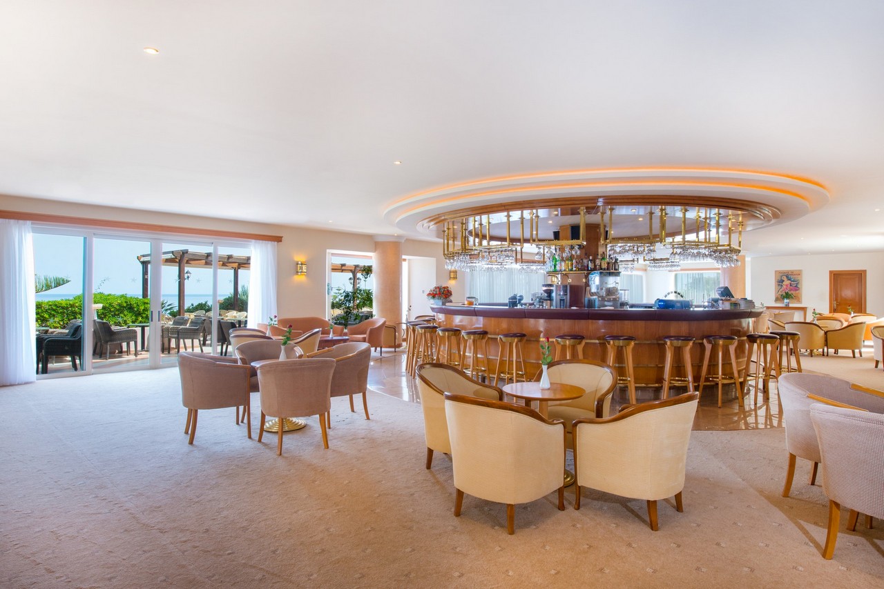 Iberostar Selection Creta Marine viesnīcas lobby bārs ar plašu atpūtas zonu, mīkstiem krēsliem un skatu uz dārzu un jūru Krētā