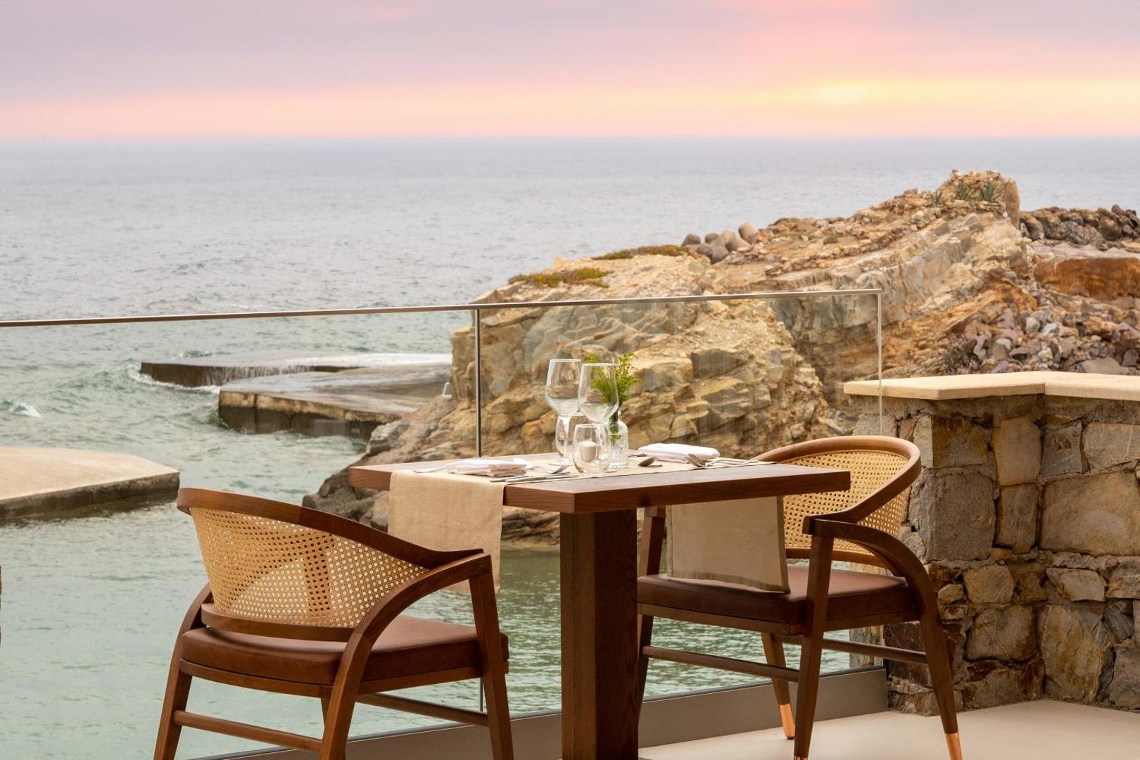 Iberostar Selection Creta Marine restorāna terases galds divām personām pie stikla margām ar skatu uz klintīm un jūru