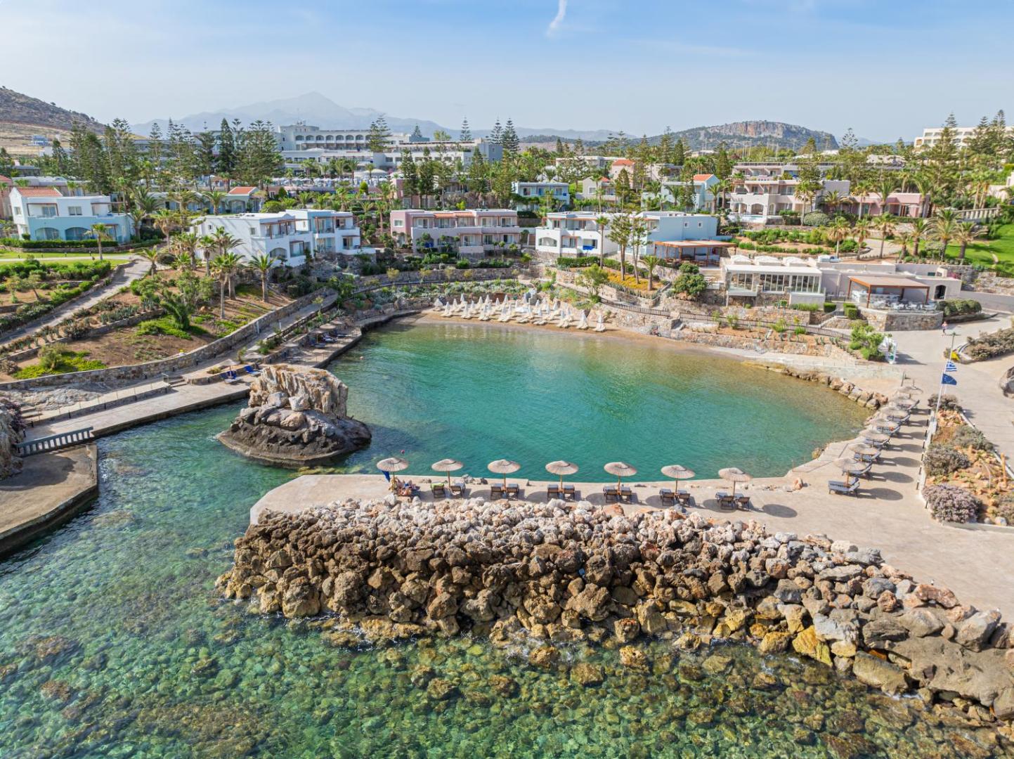 Iberostar Selection Creta Marine viesnīcas privātais līcis ar tirkīzzilu ūdeni, smilšu pludmali un saulessargiem Krētas piekrastē, Grieķijā.