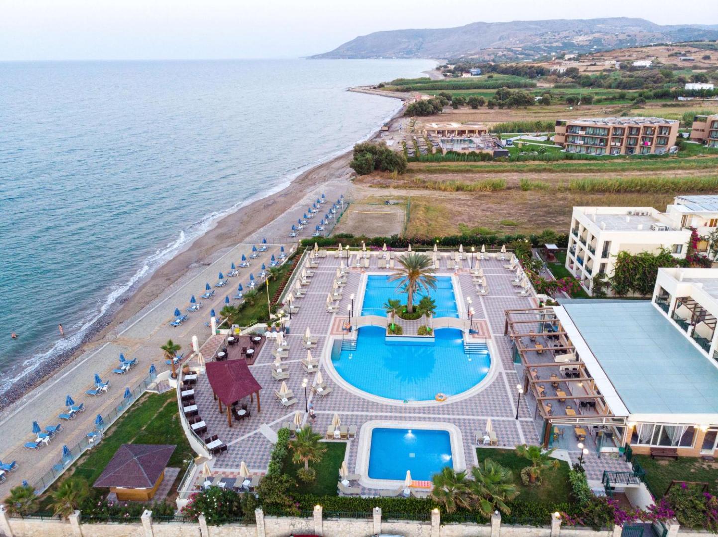 Hydramis Palace Beach Resort skats no augšas uz āra baseinu kompleksu un privāto oļu pludmali Georgiupoles piekrastē Krētā
