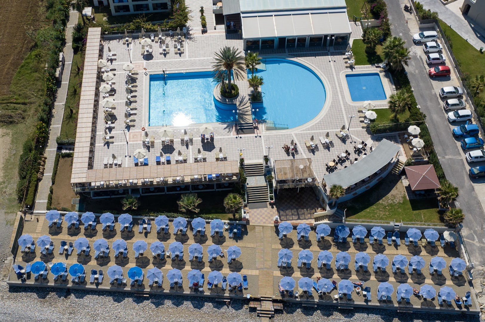 Hydramis Palace Beach Resort centrālais baseins un bērnu baseins no augšas ar blakus esošo pludmali un atpūtas zonām