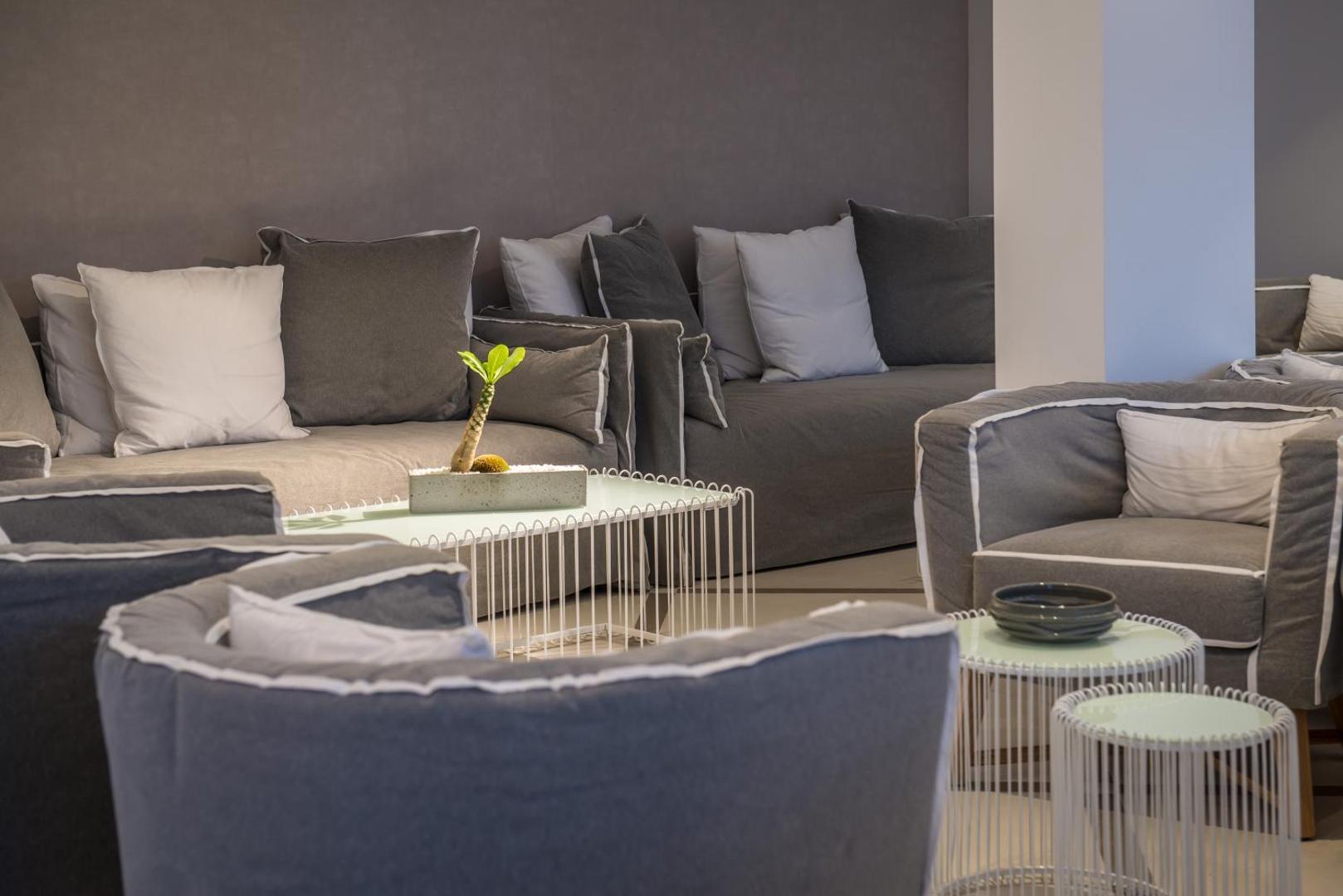 Mari Kristin Beach Hotel atpūtas zona ar mīkstiem pelēkiem dīvāniem un stilīgiem kafijas galdiņiem mājīgai relaksācijai