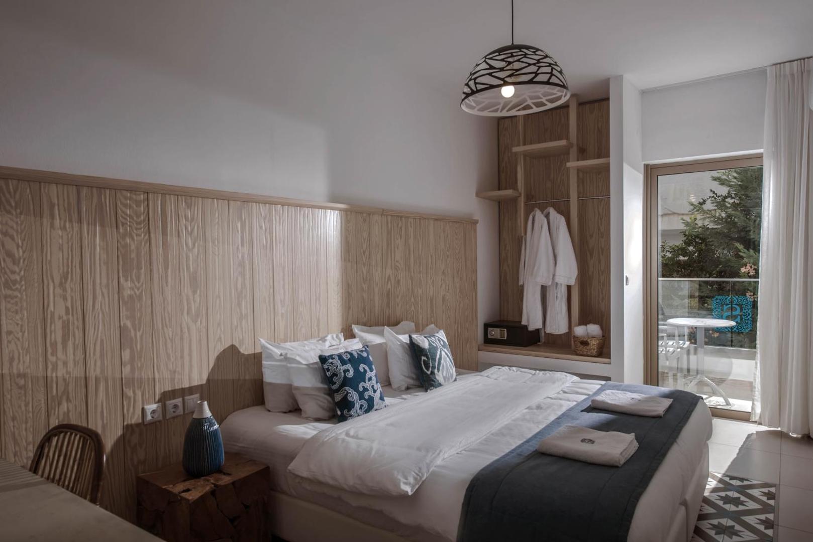 Serenity Spritz Boutique Hotel mājīgs numurs ar koka sienas paneli, dekoratīviem spilveniem un balkonu, kas vērst pret dārzu.